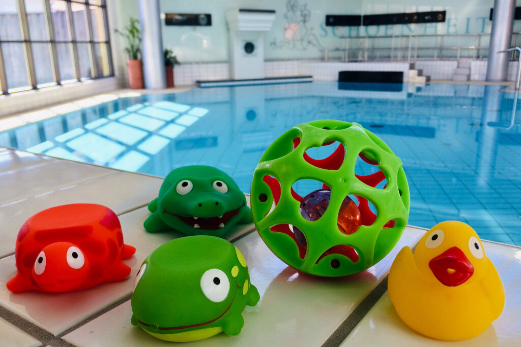 Schwimmspielzeug für Babys am Becken eines Hallenbades.